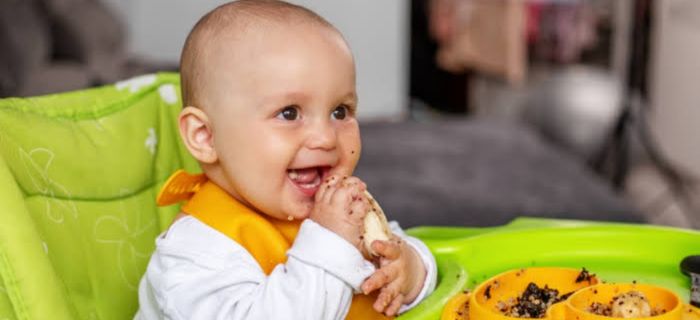 Espaço lúdico de terapia alimentar com mesa infantil, pratos coloridos e alimentos variados para estímulo sensorial, fotografia realista